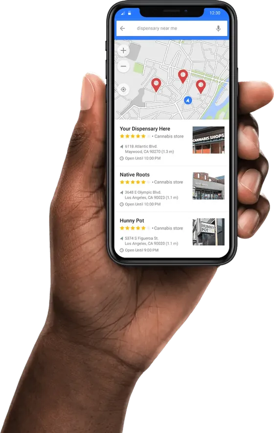 A hand holding a phone with the map results for a dispensary near me search